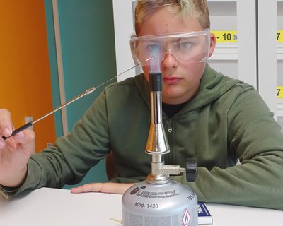 Riedenburger Modell | Ein Schüler experimentiert mit einem Bunsenbrenner und einer Flamme, LD DIDACTIC